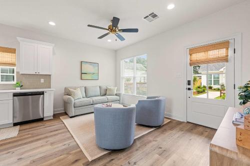 a living room with a couch and a ceiling fan at Fairway Cottage 2BR Retreat Near Sportsplex in Youngsville
