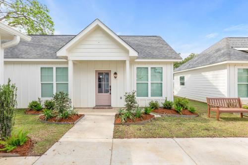 a house with a bench in front of it at Fairway Cottage 2BR Retreat Near Sportsplex in Youngsville