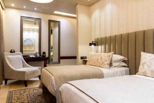 a hotel room with two beds and a chair at Kimberley Anne Hotel in Kimberley