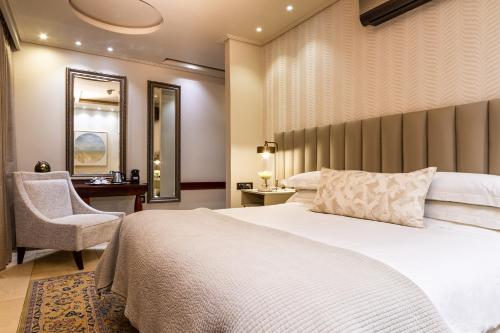a hotel room with a bed and a chair at Kimberley Anne Hotel in Kimberley