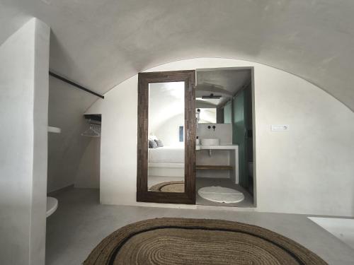 a bathroom with a mirror and a bed in a room at EXO Santorini Sea View Private Pool Villa and Suites in Éxo Goniá