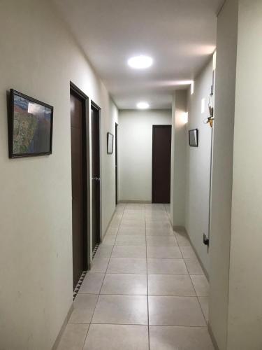 a hallway with white walls and a tile floor at Centrally located and comfortable apartment in Tupiza