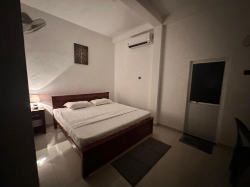 a small bedroom with a bed and a television at The Glory Villa Transit Hotel in Katunayake