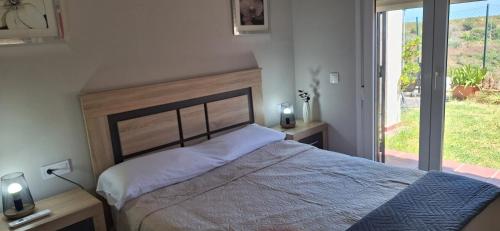 a bedroom with a large bed and a large window at Apartamento con jardin in La Línea de la Concepción