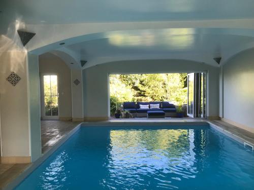 a swimming pool in a house with a living room at Rural farm stay with stunning indoor pool in Billingshurst