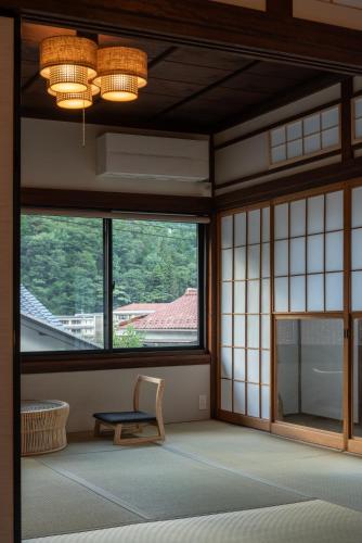 an empty room with a chair and windows at YAMO Nagiso in Nagiso