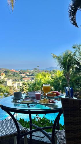een tafel met eten erop met uitzicht op de oceaan bij Pousada Pelicano in Búzios