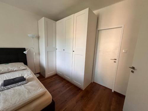 a bedroom with white cabinets and a bed and a door at Rose Valley in Bratislava