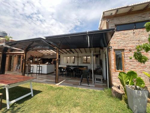 an outdoor patio with a black pergola at Zafarrancho Zárate in Zárate