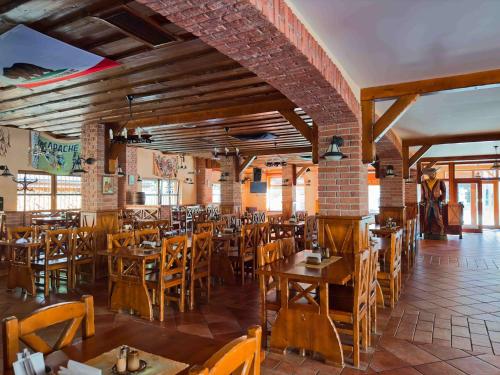 a dining room with wooden tables and chairs at Country Saloon Belá in Belá