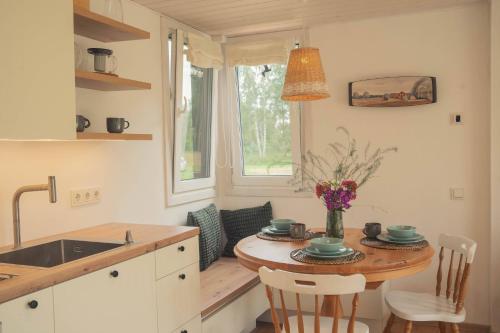 a kitchen with a table and chairs and a window at Hygge House Hiiumaa in Hiiumaa