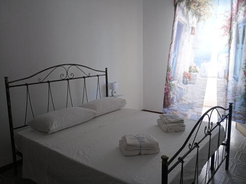 Schlafzimmer mit einem Bett mit weißer Bettwäsche und Handtüchern in der Unterkunft CarolHouse in Lido Conchiglia