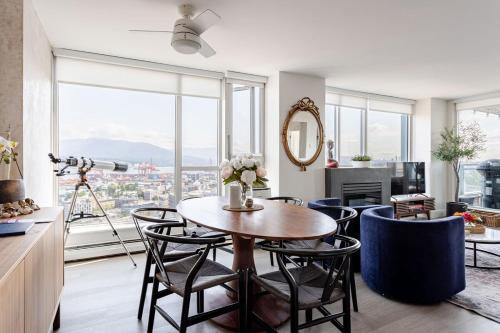 a dining room with a table and chairs and a large window at Luxury 2 Bed 2 Bath Condo Downtown Vancouver with Free Parking in Vancouver