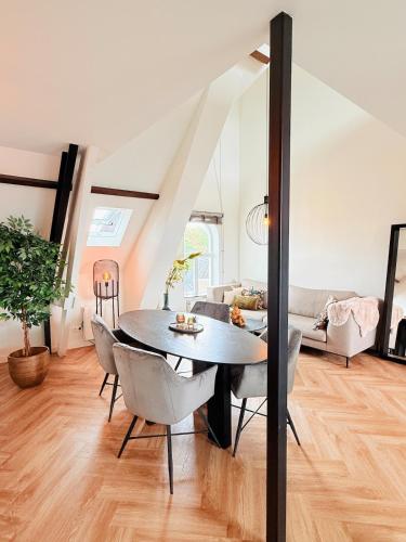a dining room with a table and chairs at Cooth's Luxury Loft with City Views in Breda