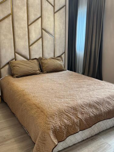 a bed with a large headboard in a bedroom at Casa Sofia&Miruna in Vladimirescu