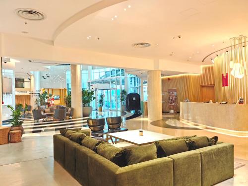 a living room with a couch in a lobby at Millennium Airport Hotel Dubai in Dubai