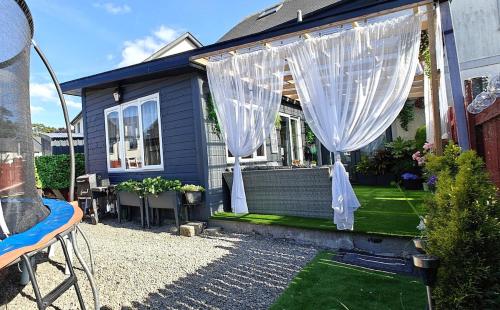 a blue house with a white curtain in a yard at Cozy cottage in Bandon in Bandon