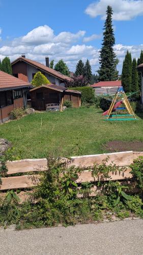 a yard with a wooden fence and a playground at Ferienwohnung Wittle in Weiler-Simmerberg