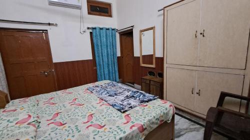1 Schlafzimmer mit einem Bett mit einer Kommode und einem 6 x 6 cm großen Bett in der Unterkunft Satwik Homestay in Ayodhya