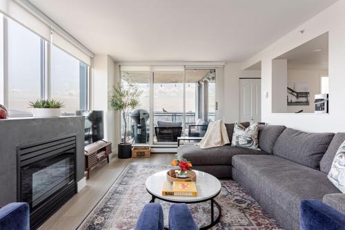 a living room with a couch and a fireplace at Luxury 2 Bed 2 Bath Condo Downtown Vancouver with Free Parking in Vancouver