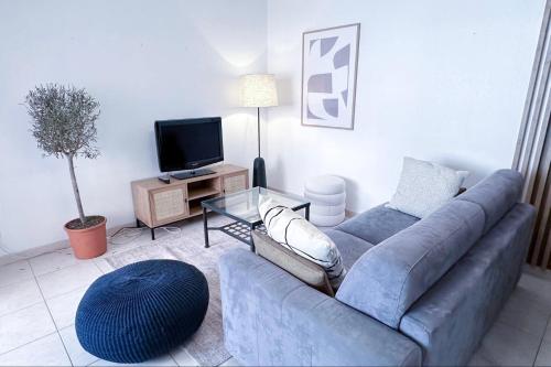 un salon avec un canapé bleu et une télévision dans l'établissement Charming T2 near the Port Vauban d'Antibes, à Antibes