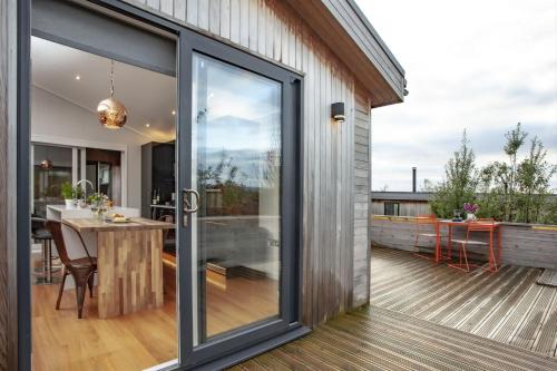 a sliding glass door on a deck with a table at Deer Leap, Strawberryfield Park in Cheddar