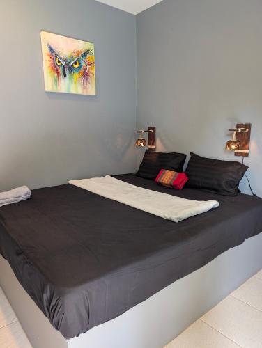 a large bed in a bedroom with a painting on the wall at Scandinavian Beach Resort in Ko Lanta