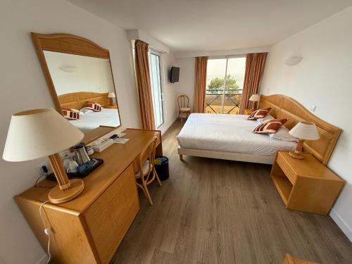 a bedroom with two beds and a large mirror at Hôtel Édenia - Spa Estime&Sens in Carnac