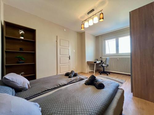 a bedroom with a large bed and a desk at City Centre Gambrinus Flat in Debrecen