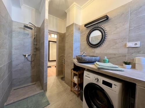 a bathroom with a washing machine and a sink at City Centre Gambrinus Flat in Debrecen