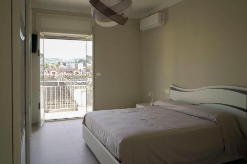 a bedroom with a bed and a large window at La voce del mare in Agropoli