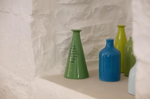 four green and blue vases sitting on a shelf at AD CALCEM Antiche Dimore Lagodentro in Terlizzi