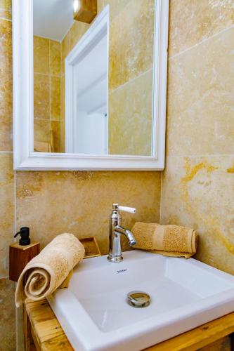 - un lavabo avec miroir et une serviette dans l'établissement U Vermentinu, à Aghione