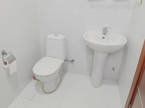 a white bathroom with a toilet and a sink at Senima's paradise - Pool & Cottages in Batumi
