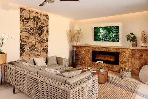 a living room with a couch and a fireplace at Palm Hotel & Spa in Petite Île
