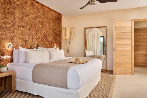 a bedroom with a large bed and a brick wall at Palm Hotel & Spa in Petite Île