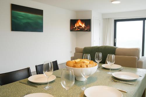 a table with a bowl of bread and wine glasses at Dingle Bay Haven in Dingle