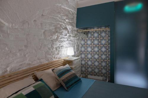 a bedroom with a bed and a wall with a lamp at AD CALCEM Antiche Dimore Lagodentro in Terlizzi