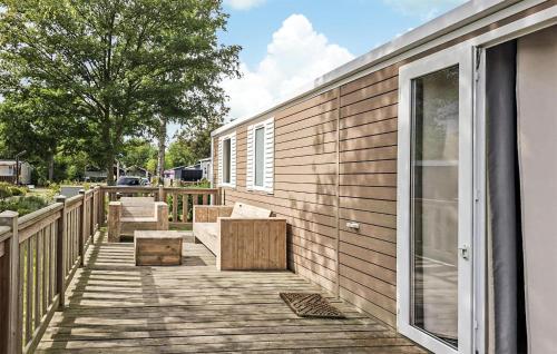 a deck with benches and a window on a house at 3 Bedroom Nice Home In Lauwersoog in Lauwersoog