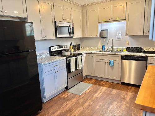 a kitchen with white cabinets and stainless steel appliances at Queen Suite - Private Entrance - WiFi in Morrow