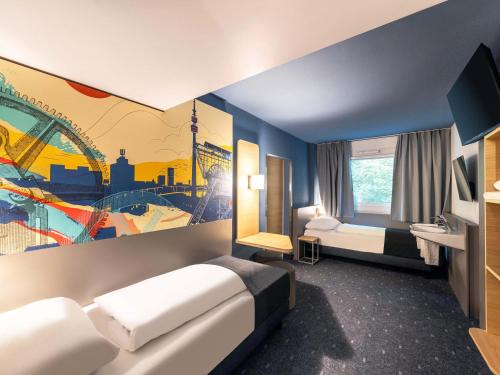 a hotel room with two beds and a painting on the wall at B&B HOTEL Dortmund-West in Dortmund