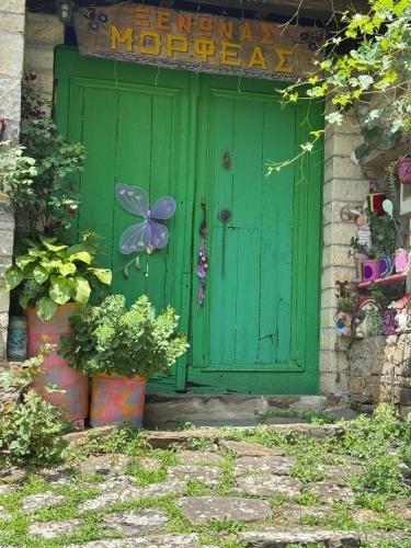 a green door with a butterfly painted on it at Morfeas Guesthouse in Papigko