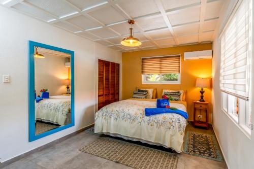 a bedroom with two beds and a mirror at Aruba Casita in Noord