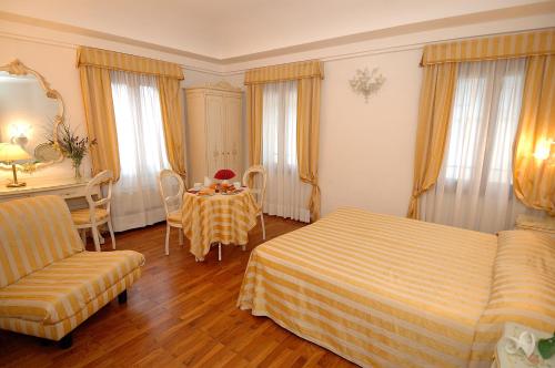 Casa Sul Molo في البندقية: غرفة نوم مع طاولة وسرير وطاولة وكراسي