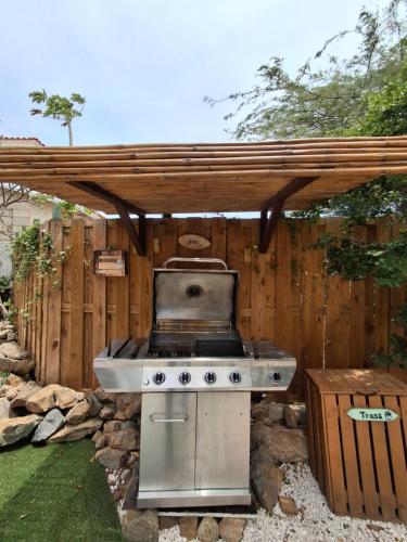a barbecue grill in a backyard with a wooden fence at Aruba Casita in Noord