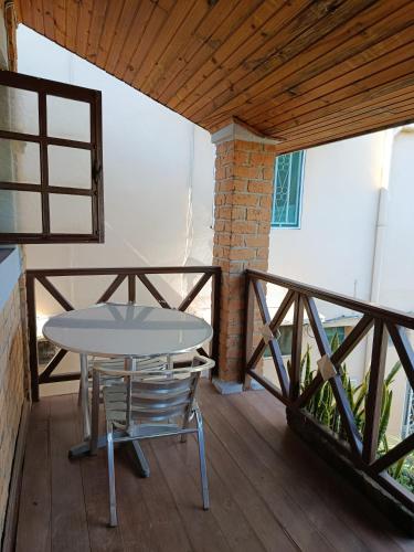 einen Tisch und Stühle auf einer Veranda mit einer Holzterrasse in der Unterkunft Hotel Mahamanina in Fianarantsoa