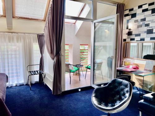 a hotel room with a chair and a desk and a room at Aura - Hotel & Restaurant & Sauna in Zielona Góra