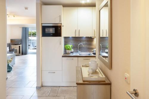 a kitchen with white cabinets and a sink at Fernweh in List