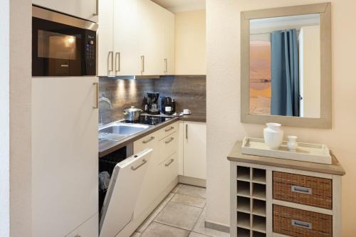 a kitchen with white cabinets and a sink at Fernweh in List