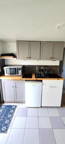 une cuisine avec des armoires blanches et un évier dans l'établissement Spacieux appartement indépendant et au calme, à Montpellier